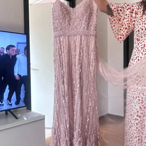 Ljusrosa långklänning med pärlor - Säljer en magisk ljusrosa långklänning som är pärlbroderad, storlek 44 använd en gång.