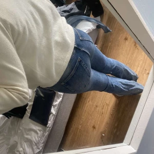 Blå bootcut jeans från weekday  - Säljer ett par klassiska blå weekday jeans med bootcut passform. Jeansen har låg midja och snyggt slitna detaljer. Perfekta för dig som gillar en tidlös och avslappnad stil. Materialet är robust denim i bomull. Lite små i storleken 