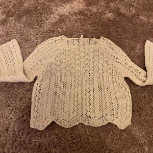 Beige stickad tröja från ONLY XS - Säljer en beige stickad tröja från ONLY i storlek XS. Tröjan har ett snyggt hålmönster och långärmade ärmar. Den har en vågig kant nedtill och är perfekt för dig som gillar en chill och feminin stil. Passar dig som vill ha något lätt och luftigt.