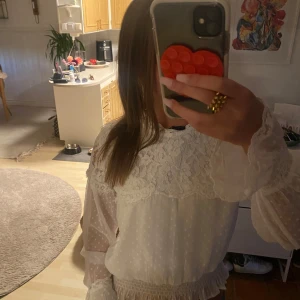 En jäte fin blus med spets  - En jätte snygg vit luftig blus perfekt för en snygg höst look kommer även med en rosett som kan fästas längst fram på blusen 