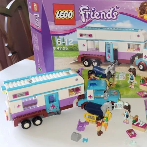 LEGO Friends 41125 - Veterinärhästtransport - Bygg och lek med Olivia och Sophie när de tar hand om hästarna! Setet innehåller en hästtransport, bil, häst, figurer och tillbehör. Perfekt för dig som gillar djur, vänskap och kreativa äventyr. Passar unga byggare som vill skapa egna berättelser. Sättet är komplett och kommer med två instruktionsböcker samt orginal boxen. Transportbilen går och rulla och det finns massa andra roliga funktioner! Perfekt present för alla och som ger massor av nöje även efter den blivit byggt! 