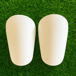 Vita mini benskydd - Säljer ett par stilrena vita benskydd som passar perfekt för fotboll. De har en slät och enkel design med en svart insida och är tillverkade i lätt plastmaterial som ger bra skydd och komfort under matchen. Perfekt för dig som vill ha en clean look på planen.