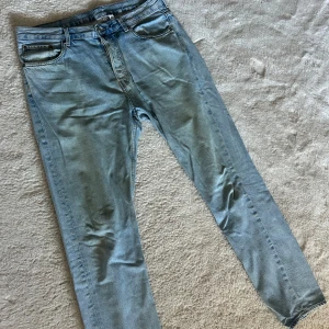 Weekday Pine jeans - Säljer ett par klassiska ljusblå Weekday Pine jeans med raka ben och normal passform. Jeansen har fem fickor, knappgylf och snygga slitningar för en chill vibe. Perfekta till sneakers och hoodie.