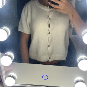 Vit kortärmad kofta med knappar - Säljer en söt vit kofta med korta ärmar. Använd fåtal gånger