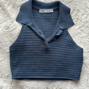 Blå stickad croppad linnetopp Zara - Säljer en blå stickad croppad linnetopp från Zara med krage och två knappar framtill. Perfekt att styla med jeans eller kjol för en trendig look.   Storlek: S men mer som en XS skulle jag säga. 