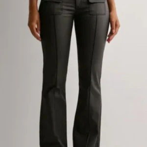 Svarta bootcut byxor med fickor - Snygga svarta byxor med bootcut och markerade sömmar framtill. Säljer då de ej kommer till användning! Endast använda ett fåtal gånger.