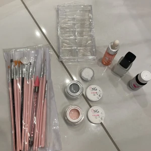 Manikyr set - -Penslar -Nagelolja -Color-Ink nr. 8(vit) -Super bonder 10ml -Två Gelfärger, grå och ljusrosa -Vitt glitter -Låda med genomskinliga lösnaglar i spetsig stiletto form.  ~Från Nagelgiganten