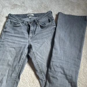 Grå bootcut jeans från ONLY XS - Snygga grå jeans från ONLY i bootcut-modell, perfekta för dig som gillar en klassisk look med lite extra vidd vid bensluten. Jeansen har fem fickor, knapp och dragkedja framtill samt bälteshällor. Materialet är mjukt denim i bomull och passar till många olika stilar. Pris går att diskutera💞
