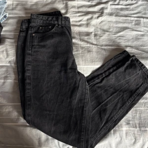 Svarta jeans strl 36 - Svarta jeans från Gina Tricot i klassisk femficksmodell med dragkedja och knapp framtill. Jeansen har raka ben och normal passform, tillverkade i slitstarkt jeanstyg. Snygga att matcha med sneakers eller boots för en chill look. Har mellan/låg midja