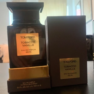 Tom Ford Tobacco Vanille 85ml - Lyxig parfym från Tom Ford, Tobacco Vanille, 100 ml Eau de Parfum. Flaskan är mörkbrun med guldiga detaljer och har en elegant, fyrkantig form. Kommer i originalförpackning med matchande mörkbrun ask och guldfärgad etikett.