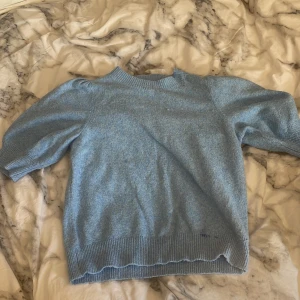 Blå stickad tröja Vero Moda XS - Mysig ljusblå stickad tröja från Vero Moda i storlek XS. Tröjan har puffiga trekvartsärmar och ribbade muddar vid hals, ärmslut och nederkant. Perfekt för dig som gillar en chill och söt stil. Materialet är mjukt och passar bra till jeans eller kjol.