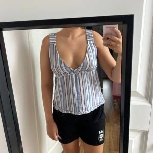 Randig linnetopp med v-ringning - Säljer en söt randig linnetopp med breda axelband och v-ringning. 