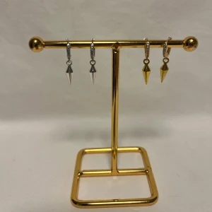 Örhängen med spetsiga hängen i guld och silver - Coola örhängen med små ringar och spetsiga, konformade hängen i både guld och silver. Perfekt för dig som gillar edgy detaljer och vill mixa metaller. Säljs som två par, ett i guld och ett i silver. Snyggt att bära tillsammans eller var för sig.