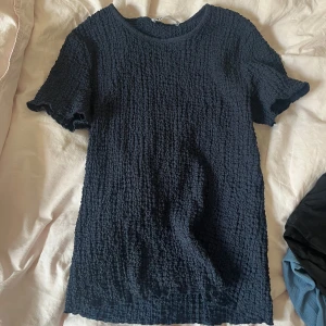 Mörkblå ribbad t-shirt - Säljer en mörkblå t-shirt med korta ärmar och coolt ribbad struktur.