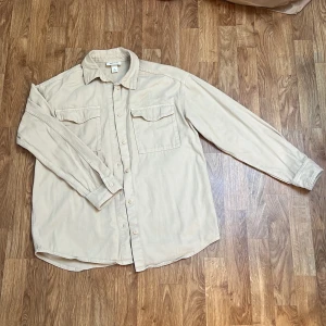 Beige oversize skjorta/tunn jacka Monki XS - Säljer en beige oversize skjorta/tunn jacka från Monki i storlek XS. Den är ganska lång (se bild) på mig som är 160cm. Material 100% bomull. Använt fåtal gånger