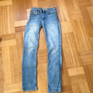 Slim fit ljusblå jeans från Dobber - Säljer ett par ljusblå slim fit jeans från Dobber, modellen The Teacher. De har midwaist, klassisk femficksdesign och snygga slitningar framtill. Perfekt passform för dig som gillar smalare jeans med lite stretch. Storlek 26.