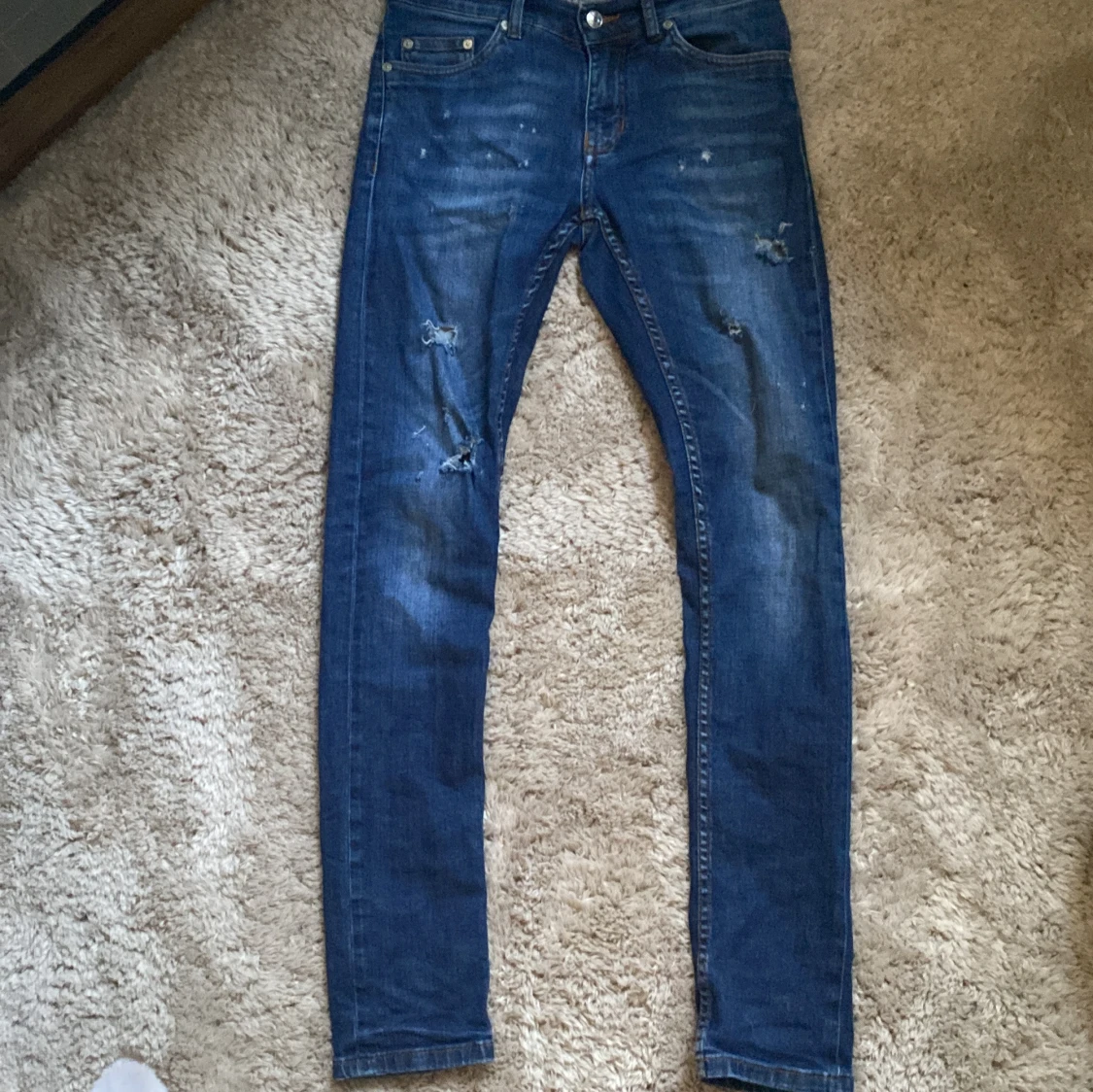 Blå jeans med slitningar