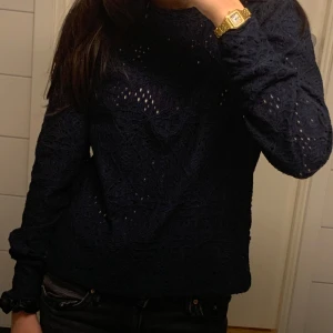 Mörkblå spetsstickad tröja Holly & White - Säljer för 80 original pris 290kr. Supersnygg mörkblå långärmad tröja från Holly & White by Lindex. Tröjan har ett spetsstickat mönster med genombrutna detaljer och puff vid axlarna. Perfekt att styla med jeans eller kjol för en cool look. Materialet känns mjukt och har en lyxig känsla.