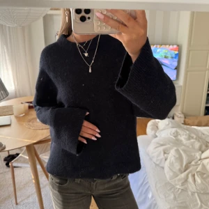 Marinblå stickad tröja i ull med vida ärmar - Mysig marinblå stickad tröja med rund hals och extra vida, långa ärmar, den är i ullblanding från Gina tricot premium quality. Det står strl m men passar mig med s. Perfekt för dig som gillar en loose fit och vill ha en enkel men snygg look. Passar till jeans eller kjol och är superenkel att styla med smycken eller lager på lager.