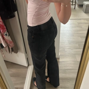 Svarta raka jeans bikbok - Säljer ett par svarta jeans med rak passform och midwaist. Klassisk femficksmodell med knapp och dragkedja framtill. Jeansen har en stilren look och är tillverkade i mjukt denim-material. Perfekt för dig som gillar enkel och clean stil. Modellen heter Mid Wide.