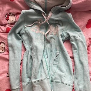 Ljusblå hoodie med dragkedja och huva - Säljer en ljusblå hoodie som tyvärr inte blir använd😢 köpt secondhand men braskick, storlek XS/S