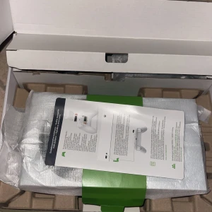 Xbox series s helt ny -    Helt ny Bilderna visar en spelkonsol, Xbox Series S, med tillbehör som handkontroll och kablar i originalförpackning. Ingen bok syns på bilderna.