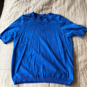 Blå kortärmad tröja från Lindex XS - En stilren blå tröja från Lindex i storlek XS. Tröjan har korta ärmar, rund halsringning. Perfekt för dig som gillar enkel och clean stil. Passar bra till jeans eller kjol för en chill look.