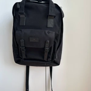 Ryggsäck  - Doughnut ryggsäck - Macaroon large cordura ryggsäck. Med framficka, rymligt innerfack, laptopfack 15 tum, blixtlåsfack, fickor på sidan, öppet fack. Endast använd en gång, nypris 1085kr.