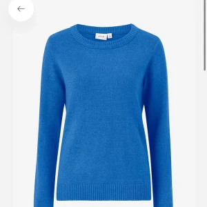 Blå stickad tröja från Vila - En klassisk blå stickad tröja från Vila med rund halsringning och långa ärmar. Tröjan har ribbade muddar vid ärmslut och nederkant, perfekt för att hålla värmen under kyliga dagar. Enkel och stilren design som är lätt att matcha. Nypris: 329kr knappt använd