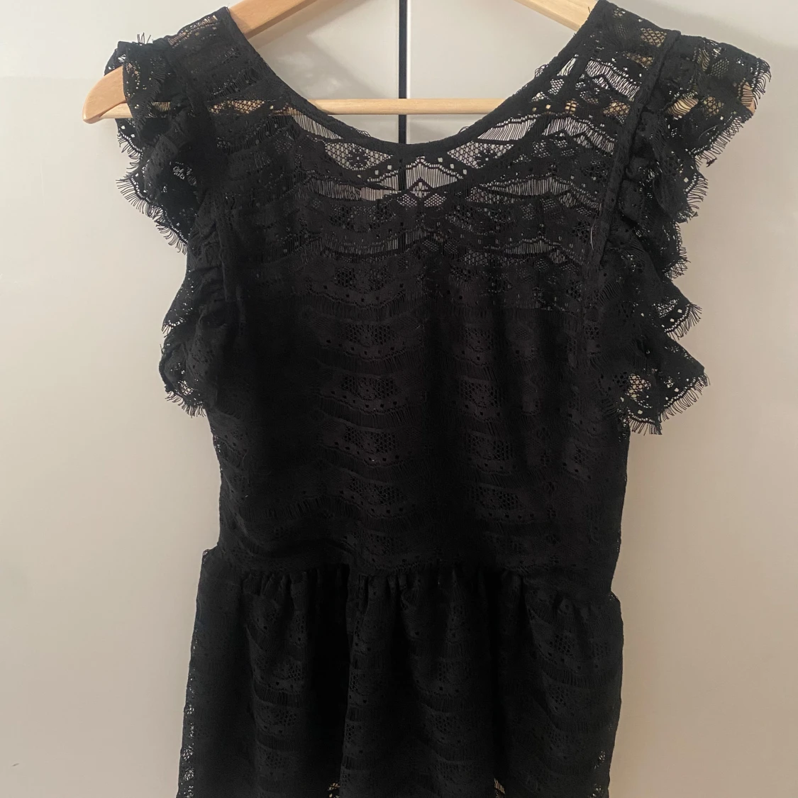 Svart spetstopp med volang