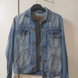 Blå jeansjacka från Crocker - Blå jeansjacka från Crocker . Jackan har två bröstfickor med lock och knappar. Storlek xs