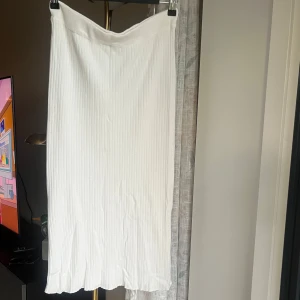 Vit ribbad kjol - Vit, ribbad kjol från Gina Tricot, i ”mid”längd. I nyskick