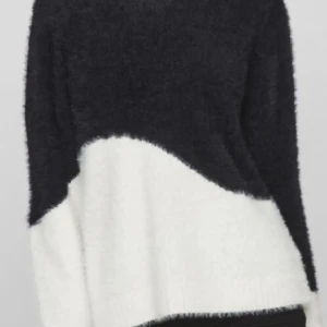 Svartvit fluffig stickad tröja - Mysig stickad tröja i svart och vitt med coolt sned färgblocksmönster. Tröjan är fluffig och har lång ärm, perfekt för kyliga dagar. Passformen är normal och materialet känns supermjukt mot huden. Enkel att styla med jeans eller kjol.