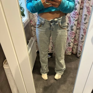 Low waist jeans  - Säljer ett par ljusblå jeans från subdued  i storlek 36. De har låg midja, raka ben och snygga detaljer med kontrastsömmar och fickor med lock och knapp bak. Perfekta för dig som gillar en avslappnad och trendig look. Köpte på Plick men tyvärr va dom för små 