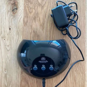 Alessandro UV-lampa för naglar - Svart UV-lampa från Alessandro International med tre timerinställningar (10s, 30s, 60s). Perfekt för att härda gelélack och skapa snygga naglar hemma. Kommer med tillhörande strömadapter.