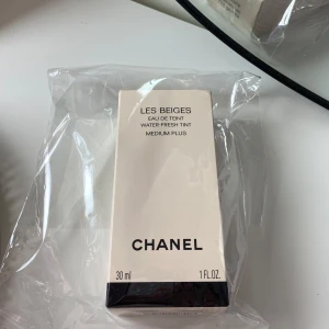 Chanel Les Beiges Water-Fresh Tint - Helt ny och plomberad. Aldrig öppnad. Tappat bort kvitto och fick därför inte byta färg i butiken. Chanel Les Beiges Eau de Teint Water-Fresh Tint i nyansen Medium Plus. En lätt foundation med naturlig finish och microdroppar av pigment. Kommer i en stilren beige förpackning, 30 ml. Perfekt för dig som vill ha en fräsch och glowig bas.