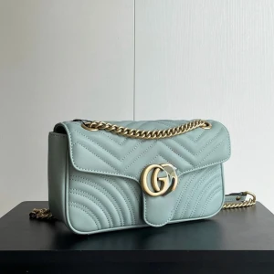 Ljusblå quiltad axelväska från Guci - Supersnygg ljusblå axelväska från Guci med quiltad design och guldfärgad kedja. Väskan har GG-logga framtill och är tillverkad i mjukt skinn. Perfekt storlek för det viktigaste och ger en lyxig touch till din outfit.