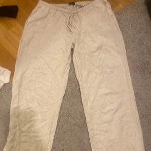 Beiga lågmidjade  linnebyxor  - Säljer ett par beiga linnebyxor från h&m som är slutsålda för tillfället , de är använda Max 2 gånger och jag har sprättat upp de där nere💕