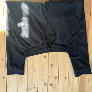 Svarta mjukisbyxor från Björn Borg - Svarta mjukisbyxor från Björn Borg med resår och snörning i midjan. Byxorna har ribbade muddar vid bensluten, två sidofickor och en bakficka. Perfekta för chill eller träning, tillverkade i mjukt bomullsmaterial.