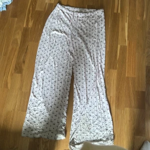 Ljusrosa vida byxor med körsbär - Supermjuka och sköna ljusrosa byxor med elastisk midja och sött körsbärsmönster. Vida ben och avslappnad passform, perfekta för chill dagar hemma. Tillverkade i viskos med lite stretch för extra komfort. Det står i storlek medium men det går säker bara i large också för den är så stretchig och stor men jag skulle inte rekommendera det här plagget för någon med s eller xs i storlek 