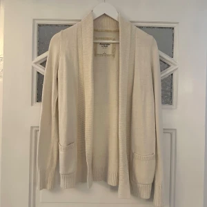 Vit kofta från Abercrombie & Fitch - Vit kofta från Abercrombie & Fitch. Koftan har långa ärmar och ribbade detaljer vid ärmslut och krage. Nypris ca 700kr