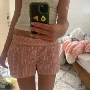 Rosa blommiga shorts med mönster - Säljer dessa supersöta rosa shorts med vitt blommigt och randigt broderat mönster💓💓