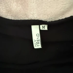 Svart knyt-topp från NLY Trend - Svart topp från Nelly med snygga knytband i midjan i strl M.