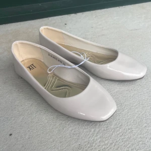 Beige ballerinaskor från din sko  - Snygga beige ballerinaskor från din sko med fyrkantig tå och glansig finish. Aldrig använda. Nypris 300 kr
