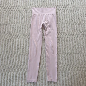 Ljusrosa seamless leggings  - Säljer ett par ljusrosa seamless leggings från Aim'n med hög midja och ribbade detaljer längs sidorna. Diskret Aim'n-logga framtill på linningen. Endast använda ett fåtal gånger🩷