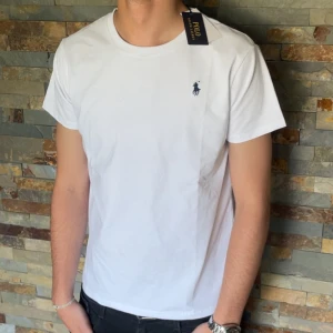 Vit polo Ralph lauren T-shirt  - En riktigt snygg vit Ralph lauren T-shirt. Denna är väldigt välkänd och många vill ha den. Storleken är S men passar även M. Skicket är helt nytt och den är perfekt, 10/10. Priset jag kommer sälja den för är 399kr men kan sänka priset vid snabb äffär. Kom med prisförslag. Kontakt mig vid några funderingar. 