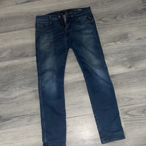 Mörkblå skinny jeans med slitningar - Snygga mörkblå jeans med skinny fit och lätt slitna detaljer på låren. Klassisk femficksmodell med dragkedja och knapp. Jeansen har en smal passform och är tillverkade i stretchigt denim för extra komfort.