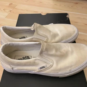  Vans vita storlek 37!  -  Klassiska Vans,  i vit canvas med låg profil och elastiska sidor för enkel påtagning. Skorna har rund tå och vit platt sula med Vans logga bak. Perfekta för en avslappnad streetstil. De har inga anmärkningar , inga skador, inte slitna.