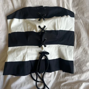 Randig svartvit korsett med snörning - Snygg axelbandslös korsett från H&M i svart och vitt med breda ränder. Aldrig använd och prislappen är kvar!🤩🤩
