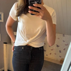 Vit croppad t-shirt med knyt - Snygg vit t-shirt med korta ärmar och knyt framtill. Passar till mycket och har ett mjukt material!🛍️💞